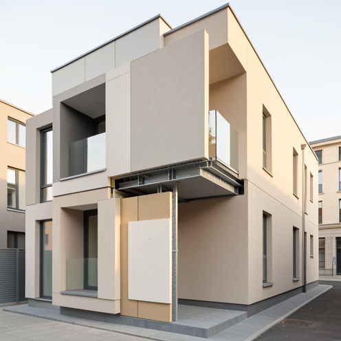 Façade moderne écoénergétique présentant des panneaux d’isolation, un enduit minéral et des finitions architecturales soignées.